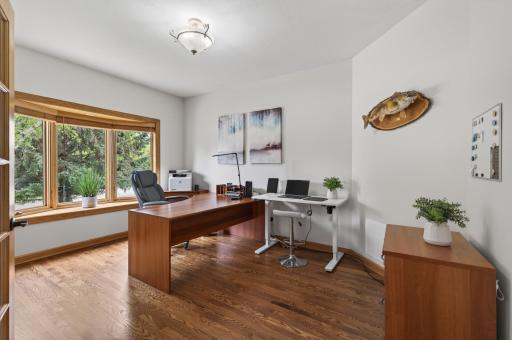 Main level office with hardwood floors, large picture window, and flexible workspace.