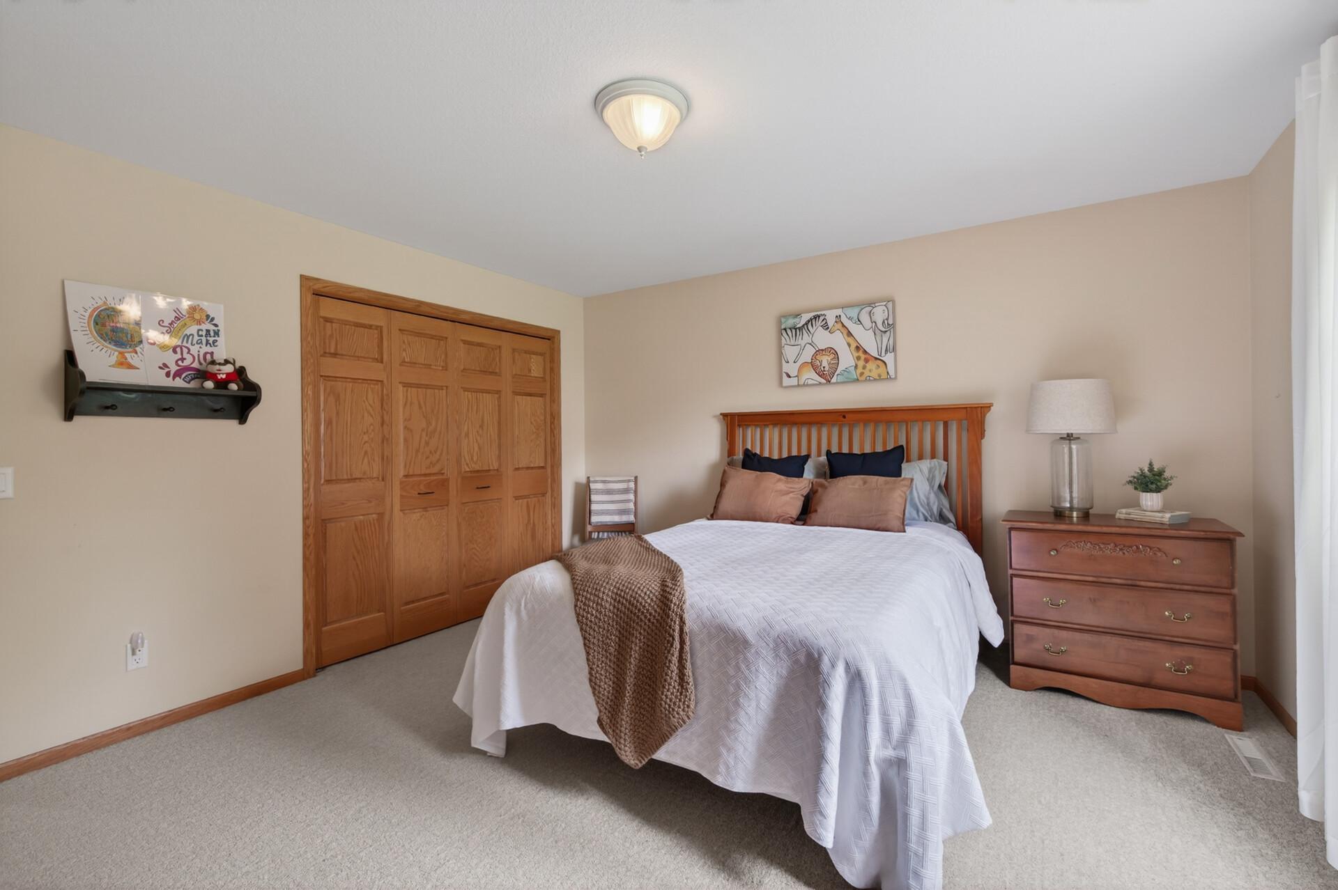 Bright secondary bedroom featuring oversized closet and soft neutral décor.