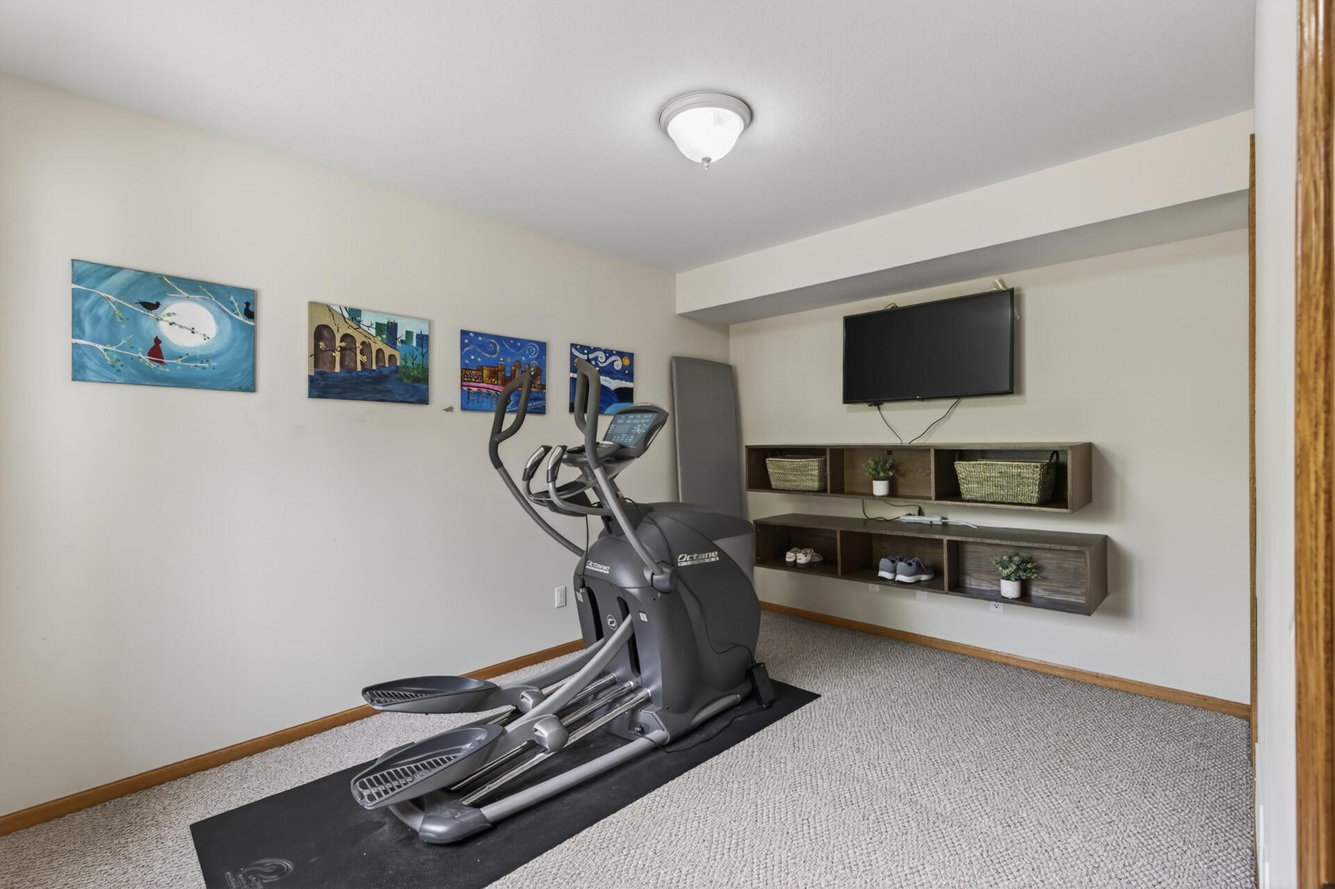 Flexible lower-level 4th bedroom used as a bonus room ideal for a home gym, media room, or hobby space.