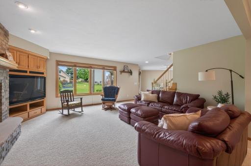 Comfortable lower-level living area with oversized windows and built-in entertainment center.