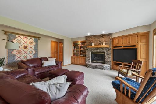 Expansive lower-level family room with brick fireplace, custom built-ins, and abundant gathering space.