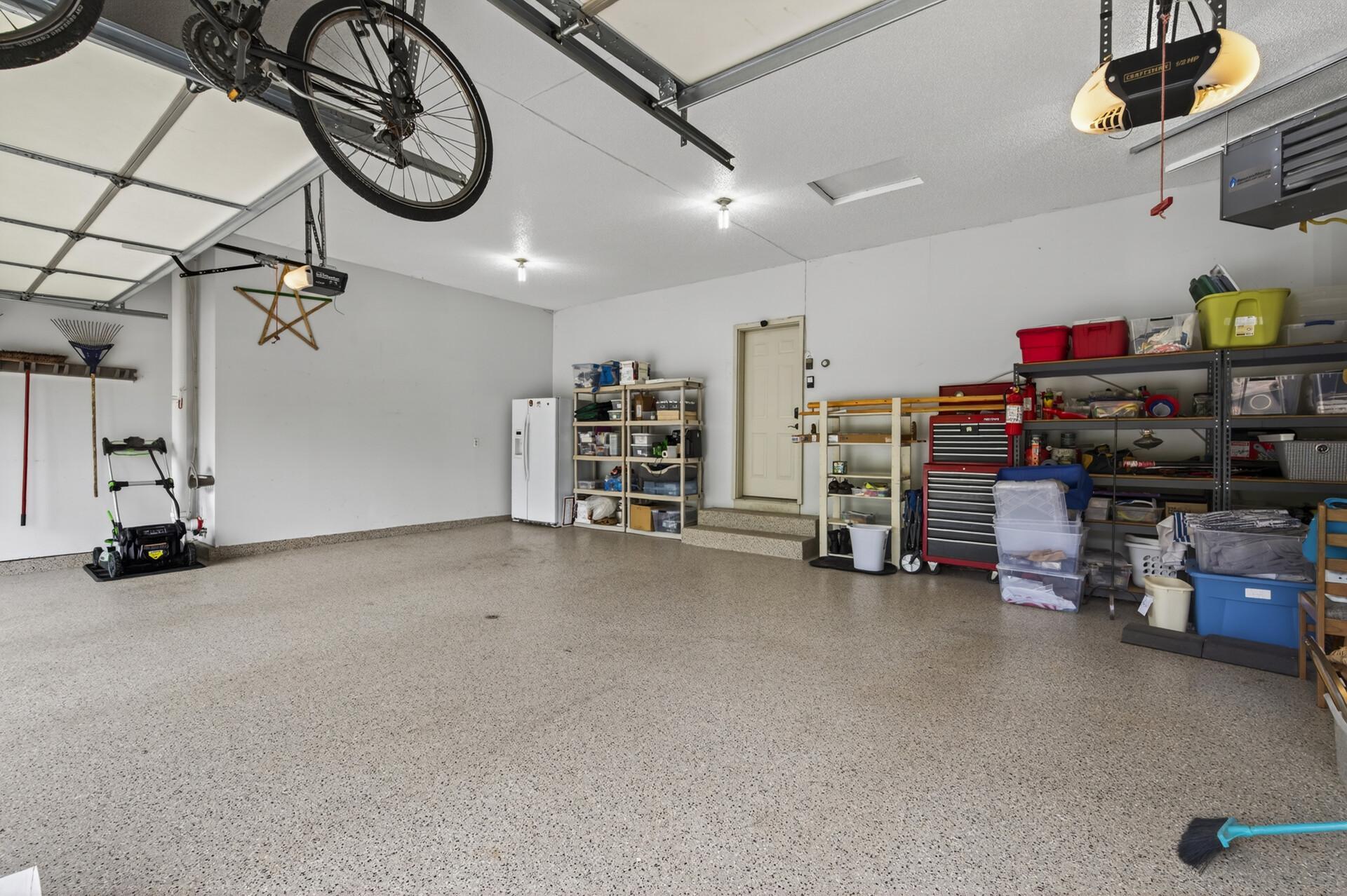 Expansive heated garage with durable epoxy floors and ample room for vehicles and storage.
