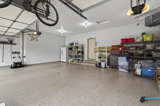 Expansive heated garage with durable epoxy floors and ample room for vehicles and storage.