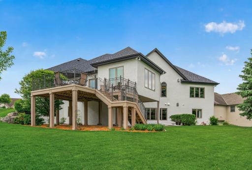 Elevated deck and staircase create seamless indoor-outdoor living and entertaining space.
