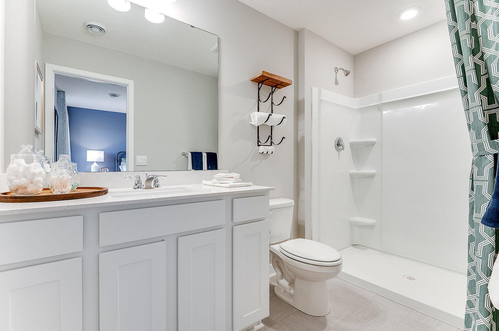 Private en suite bathroom off primary with double vanity and walk-in shower. (Model photo, colors may vary)