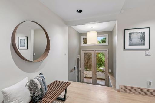 Welcoming entry with warm wood floors and views to the private outdoor setting.
