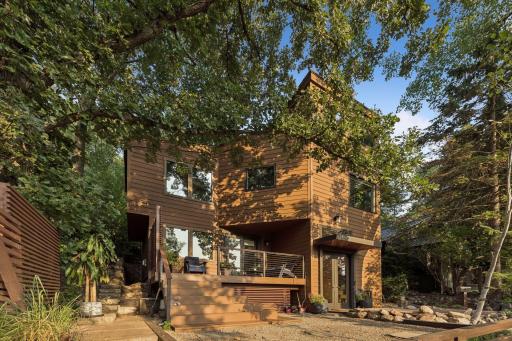 Architectural exterior nestled among mature trees and natural surroundings.