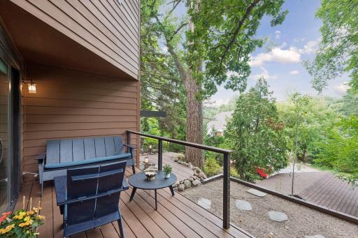Expansive deck overlooks the lush, tree-filled setting and private grounds.