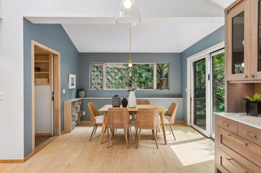 Sunny dining area features wooded views and a striking stone accent wall.