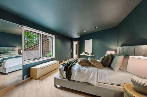 Primary bedroom with custom built-ins and wooded views.