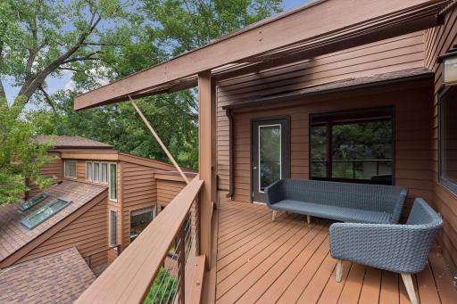 Private rear elevation blends naturally into the wooded landscape with multiple outdoor spaces.