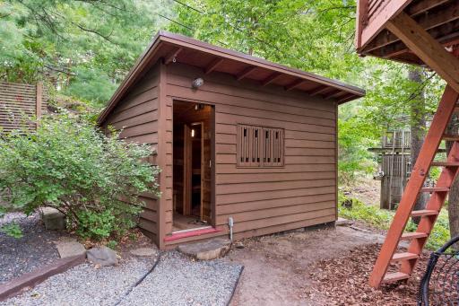 Charming custom sauna nestled among the trees, adding a unique wellness retreat to the property.