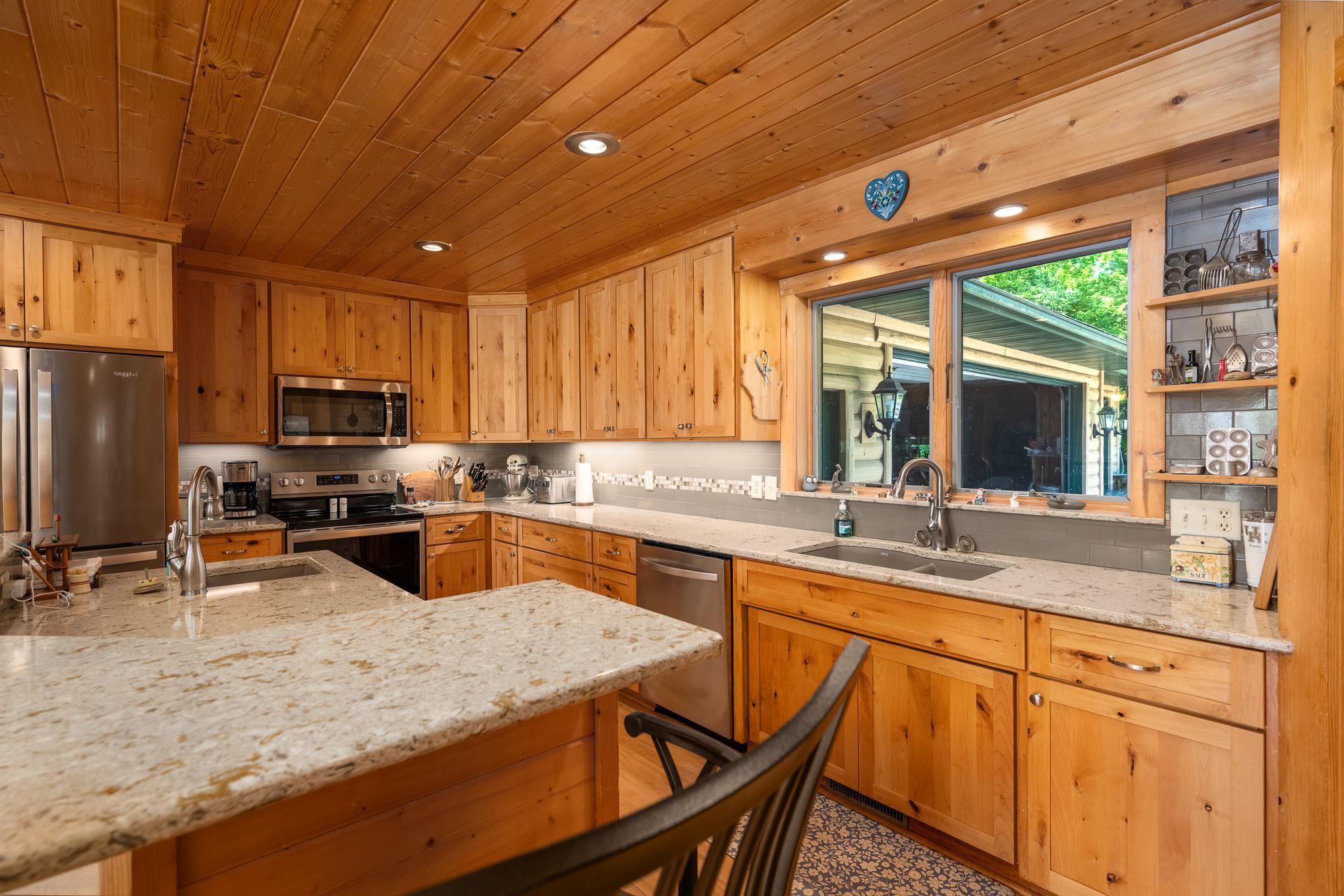 hickory cabinets, quartz counter tops and a view of the back yard, very wooded and serene