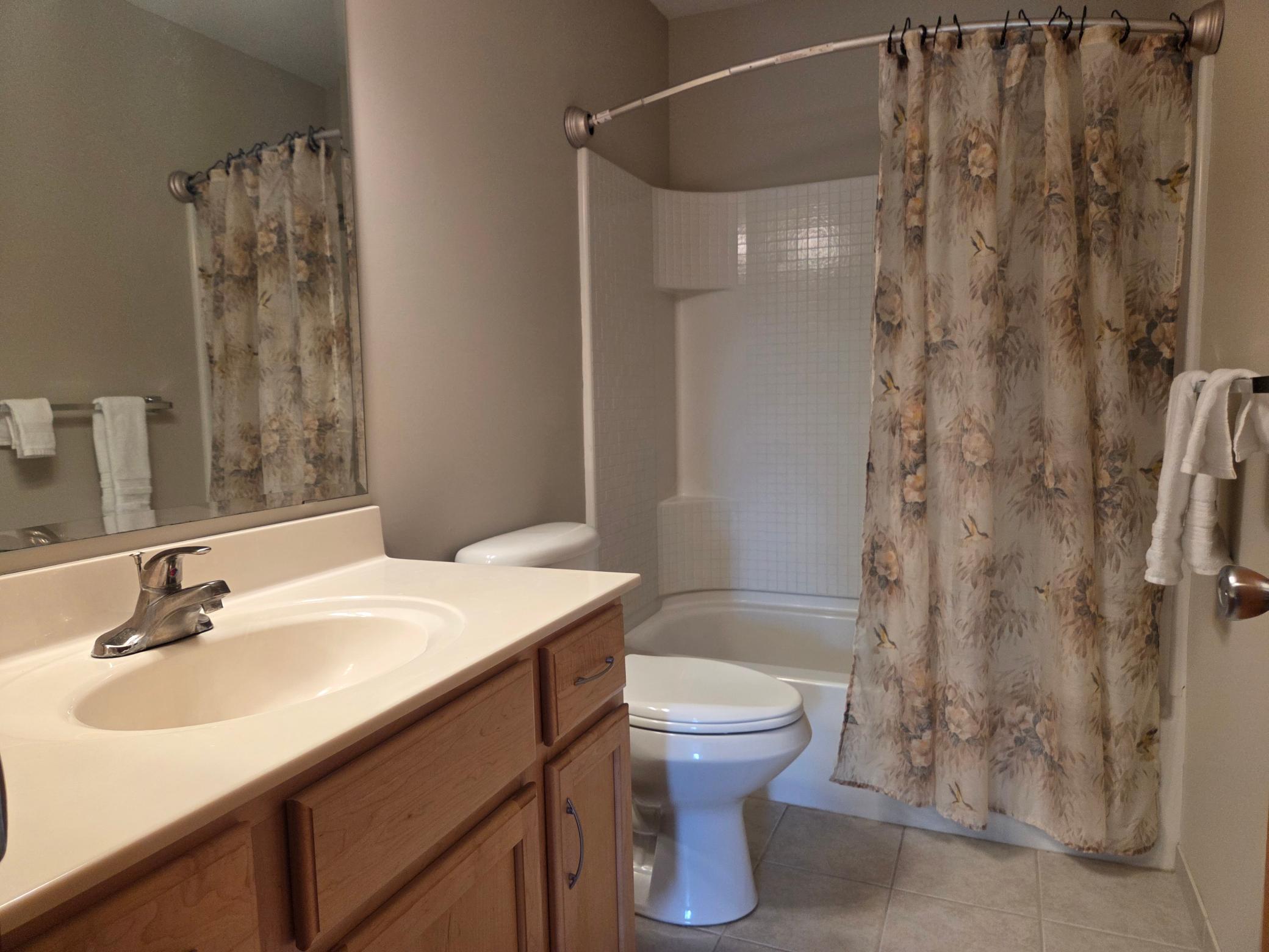 Main bath with ceramic floor and shower surround.
