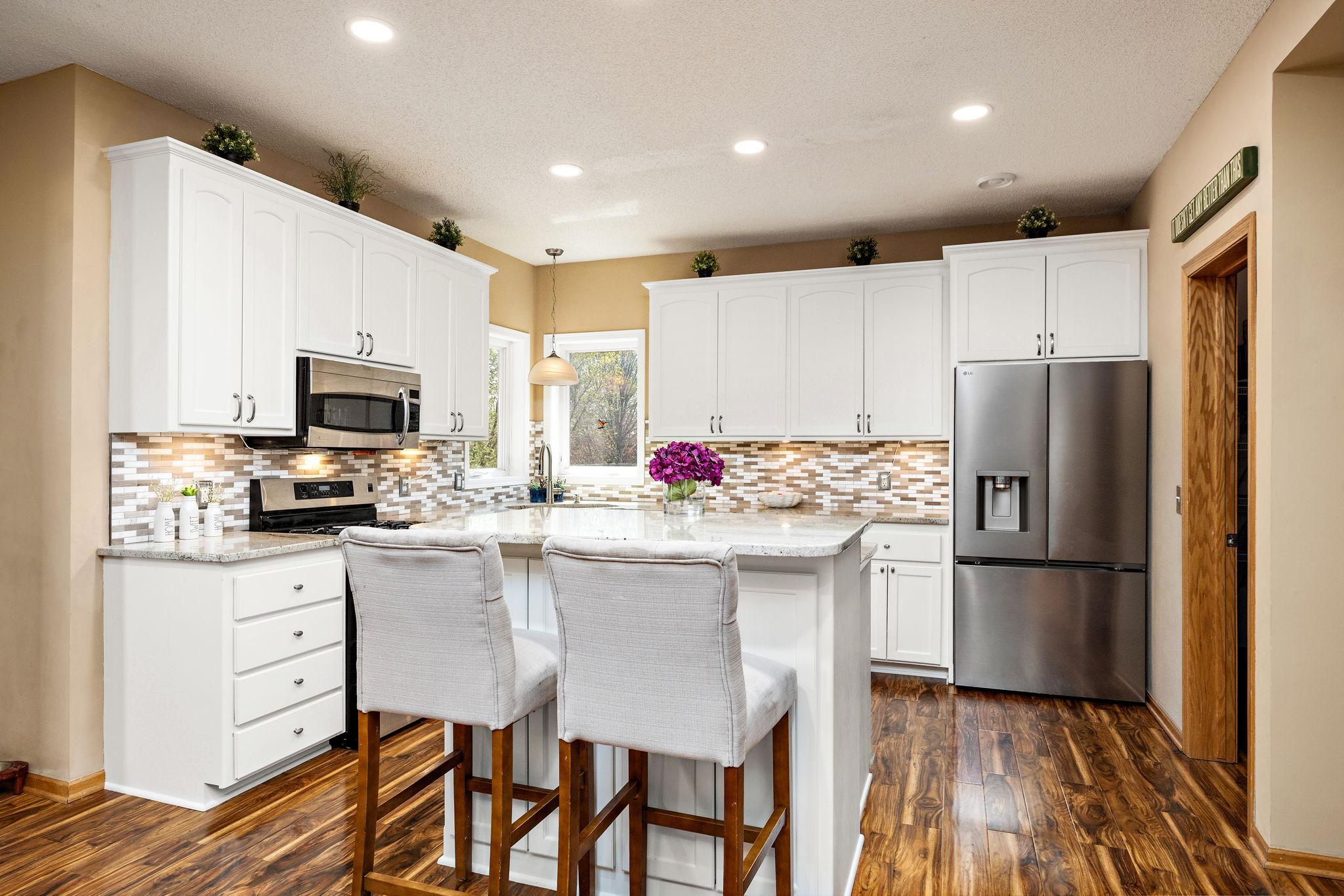 Kitchen has granite counter tops and corner window