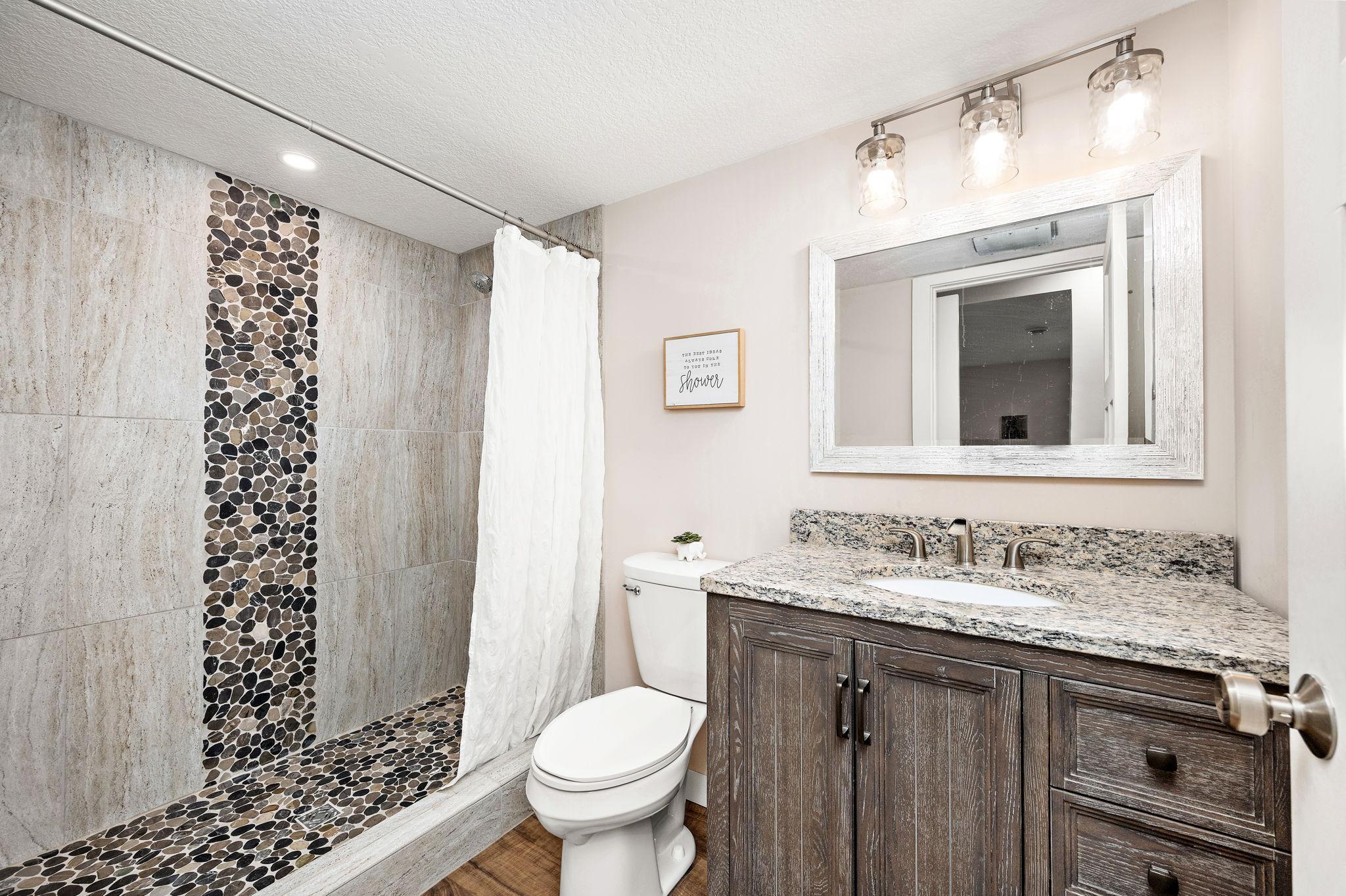 Lower level 3/4 bathroom granite countertop and tiled shower
