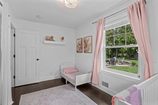 Additional spacious, main-level bedroom features double windows, gorgeous floors and neutral, white color palette creates a relaxing and cozy space.
