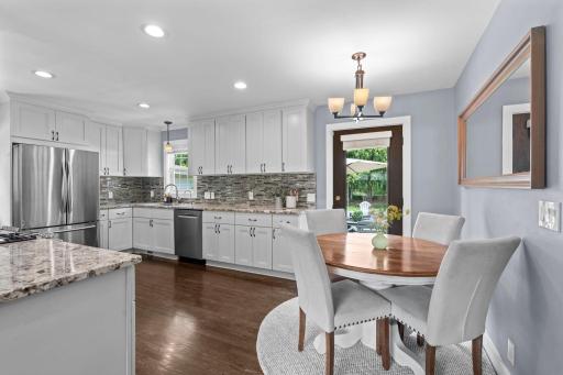 Beautiful hardwood floors, white cabinetry, crown molding, paneled Craftsman-style doors, and a neutral color palette create a warm and inviting atmosphere throughout the home.