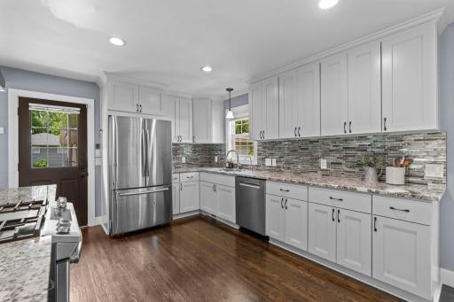Abundance of beautiful white cabinetry and stainessl steel appliances.