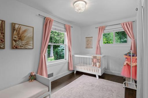 Additional spacious, main-level bedroom features double windows, gorgeous floors and neutral, white color palette creates a relaxing and cozy space.