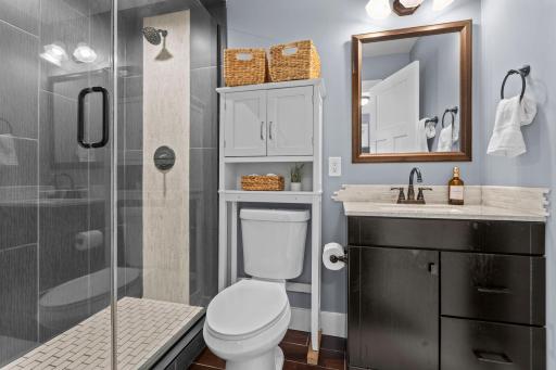 Serene primary suite offers a private Â¾ bath showcasing a stunning tiled walk-in shower with rainfall shower head.