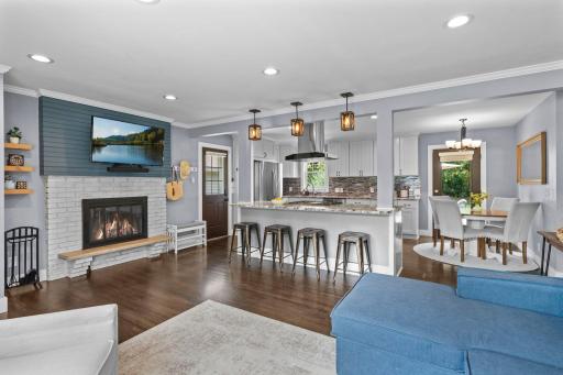 Charming living room is highlighted by a brick fireplace with tasteful shiplap accents. Gorgeous hardwood floors spans the main level.