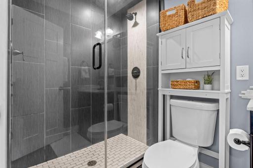 Private Â¾ bath showcasing a stunning tiled walk-in shower with rainfall shower head