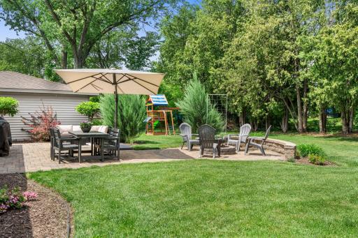 The tree-lined backyard is a true standout, featuring a paver patio retreat, separate firepit area, expansive green space âperfect for entertaining, recreation, or quiet evenings outside.