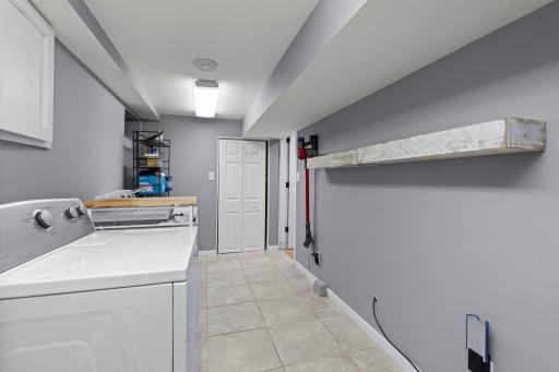 Finished laundry space with ceratmic tiled floors.