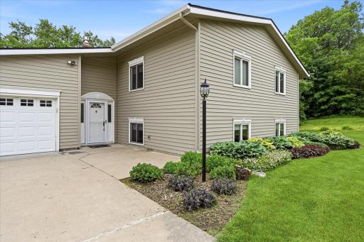 Cement driveway with large entry. Landscaping around the front is filled with hastas, coral bell and assorted perrenials.