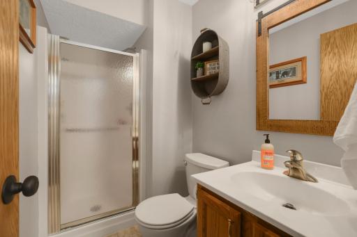 This lower-level bathroom is clean, functional, and thoughtfully updated with a warm, neutral design. Featuring a walk-in shower with frosted glass doors, updated fixtures, and easy-care finishes, the space offers both comfort and convenience.