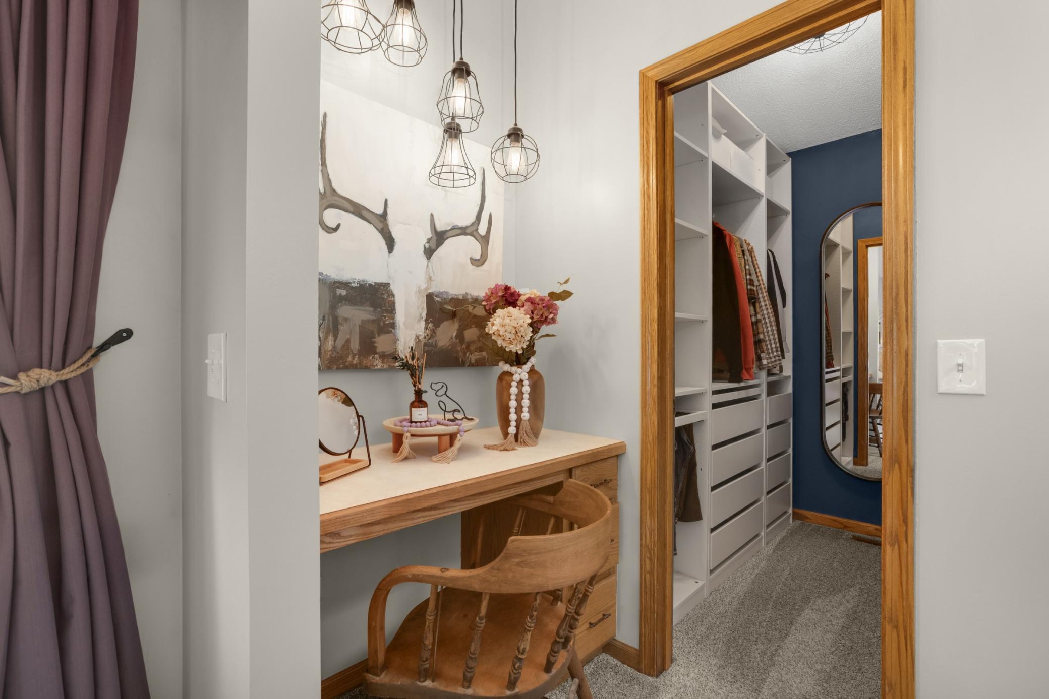 Elegant pendant lighting and warm wood accents create a cozy, upscale atmosphere, while the built-in vanity provides the perfect space for getting ready each day