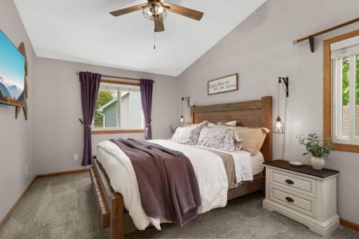 The spacious primary bedroom offers a peaceful retreat with soaring vaulted ceilings, soft neutral tones, & abundant natural light. The room easily accommodates a king-sized bed and features stylish updated lighting, & gives you the feeling of space