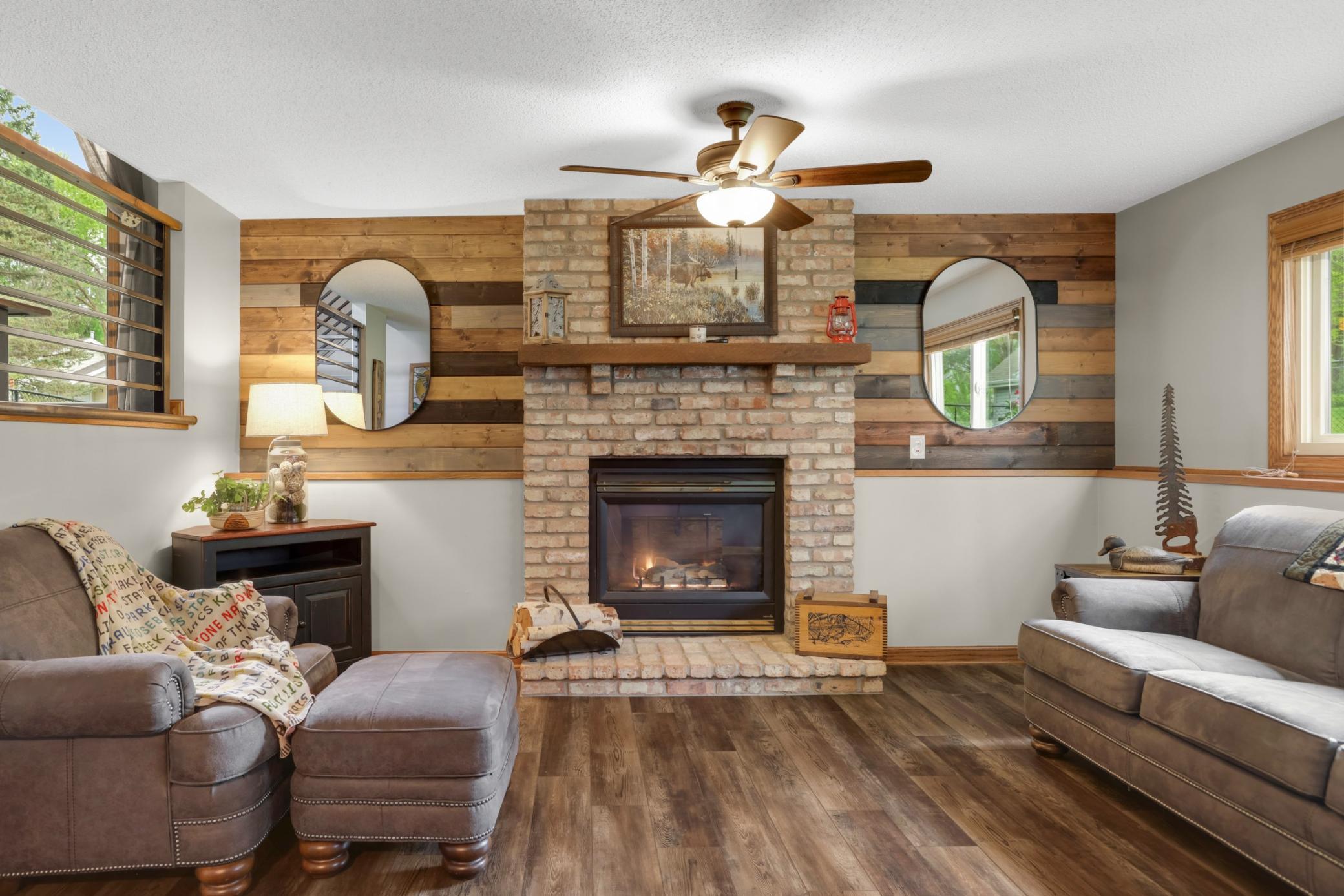 The space creates an inviting atmosphere ideal for relaxing or entertaining. Rich wood tones, updated flooring, and large daylight windows bring warmth and natural light into the room while showcasing beautiful backyard views.