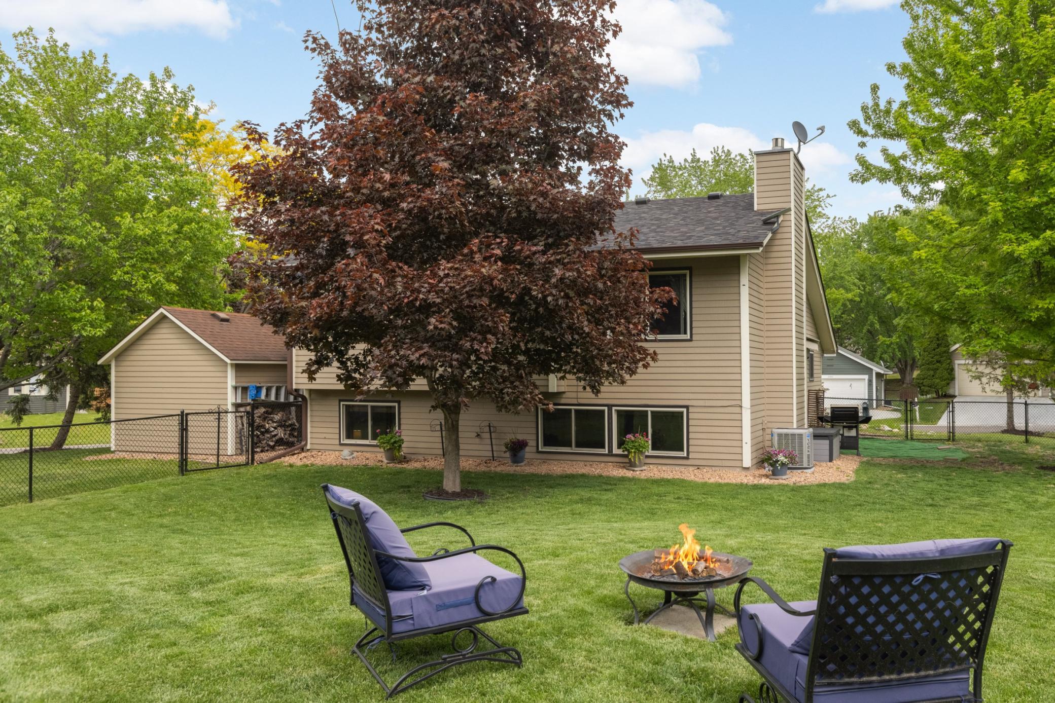 Mature shade trees and well-maintained landscaping create both privacy and natural beauty throughout the yard.