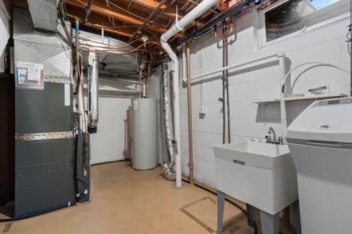 Spacious lower-level utility room offers ample storage and is already set up with flexibility to add a second laundry area if desired. New HVAC, water heater, and active radon mitigation system.