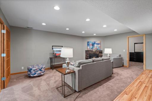 Spacious lower-level family room features a cozy electric fireplace and convenient access to bedroom 6, creating an ideal space for guests, multi-generational living, or private retreat.