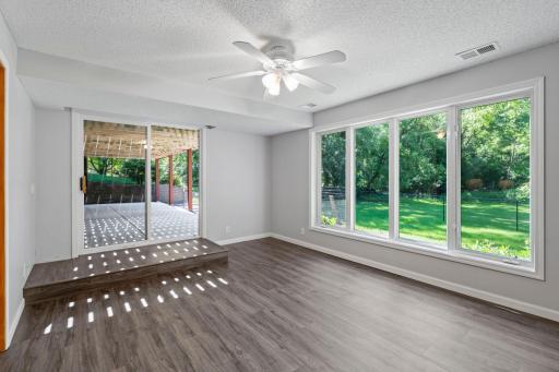 Lower-level sunroom with walkout to patio under deck.