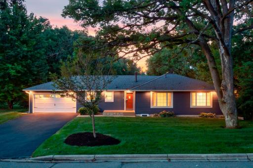 Exceptional curb appeal welcomes you home with mature trees, a manicured lawn, and a peaceful setting that offers both beauty and privacy. 16633 Temple Drive N, Minnetonka, MN.