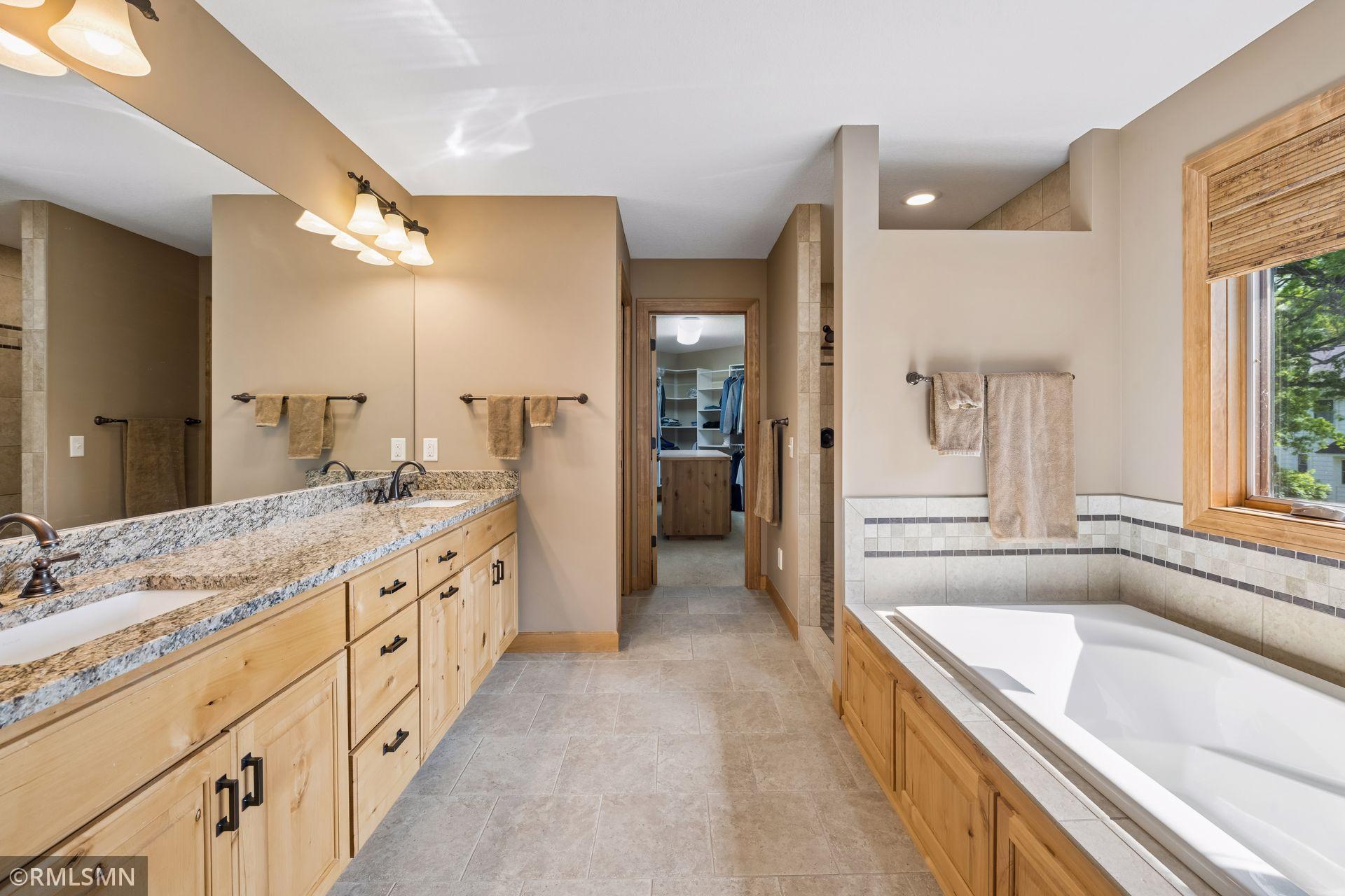 Primary bathroom with full soaking tub, walk-in shower, and in-floor heat