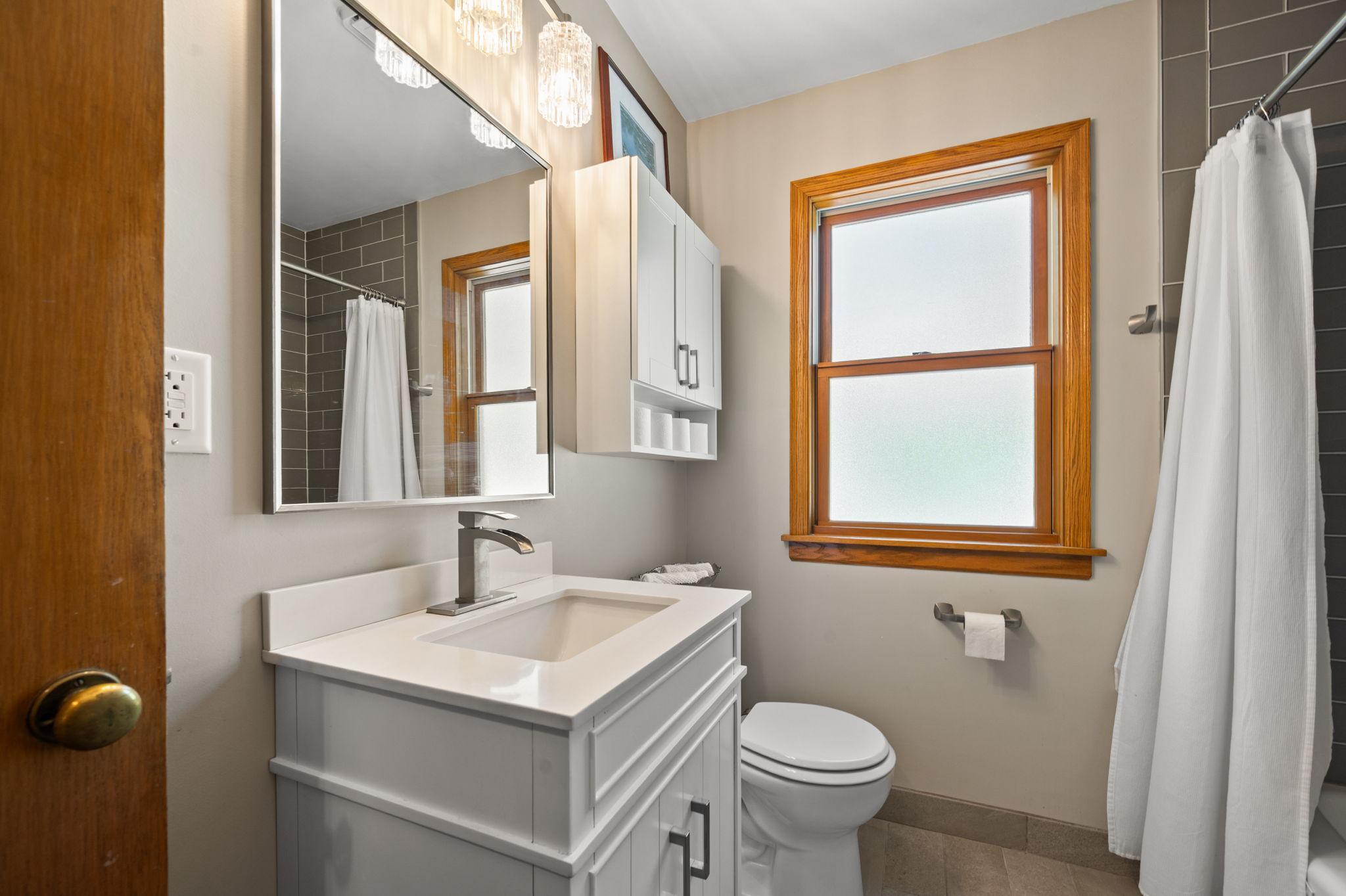 Well Updated Bathroom with Vanity, Mirror, Lighting and Storage Cabinet