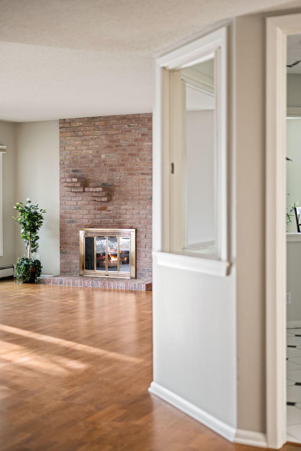 Charming interior view highlighting the cozy brick fireplace and open layout.