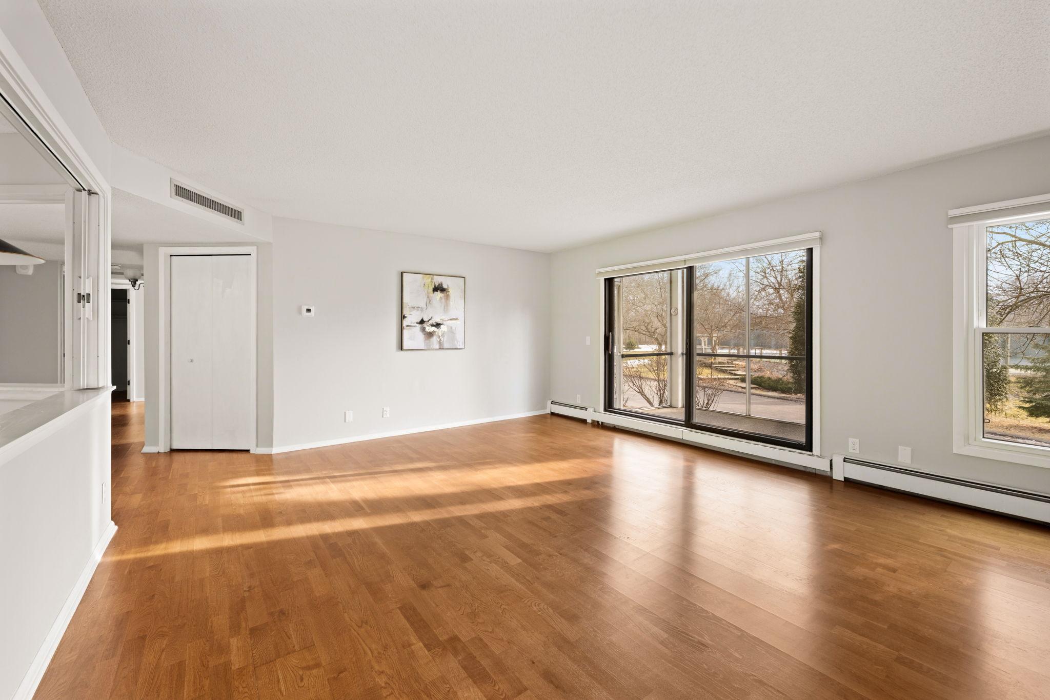 Light-filled living room with expansive windows, hardwood floors, and plenty of space for entertaining.