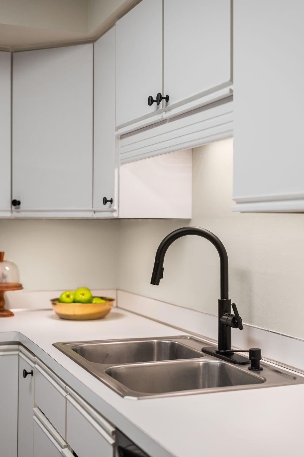 Kitchen detail featuring a double-basin sink, updated faucet, and generous workspace.