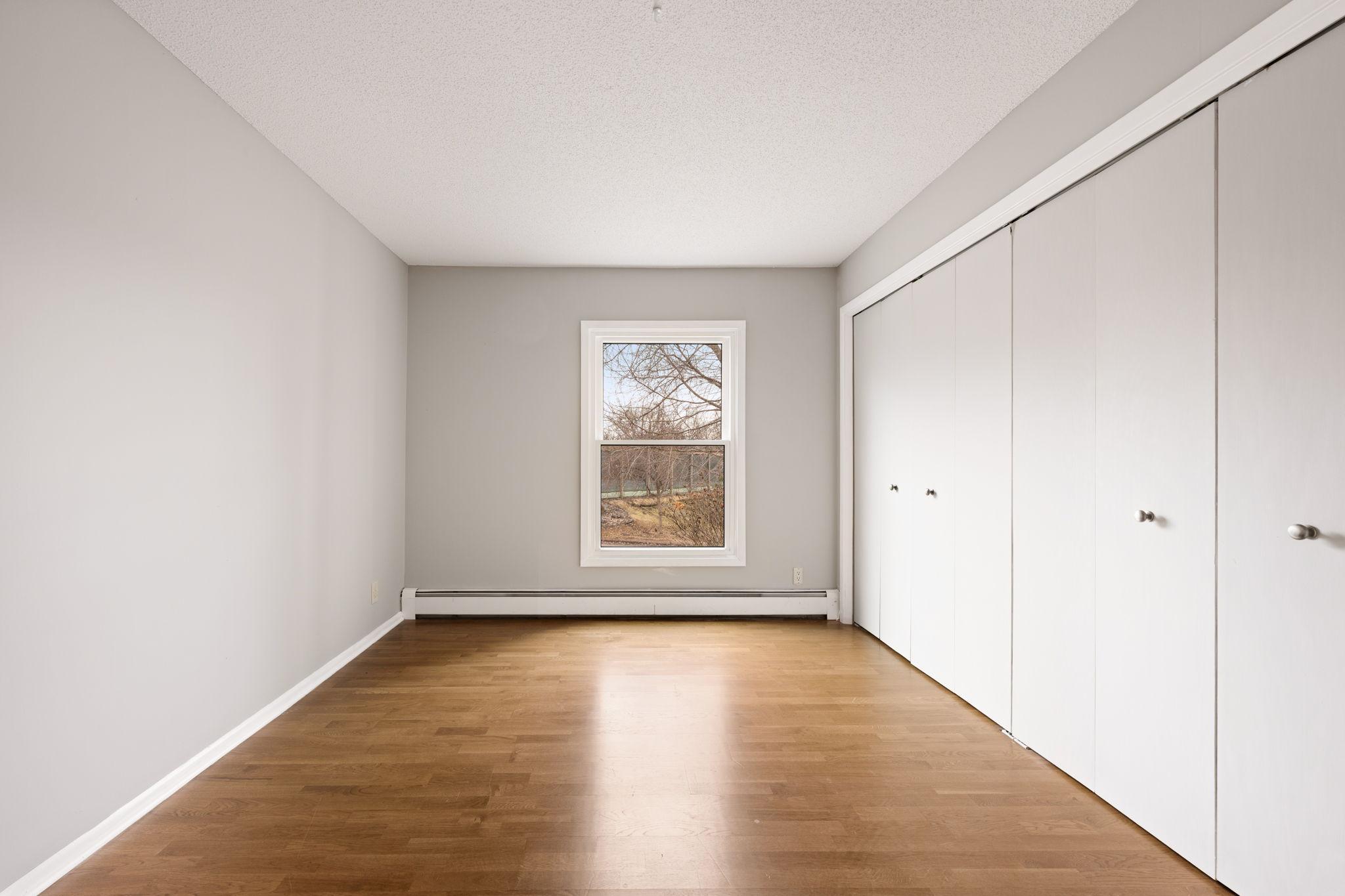 Additional view of second bedroom with window views and abundant closet space.