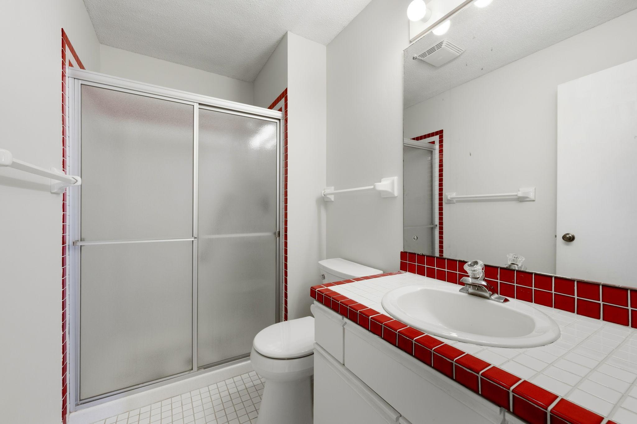 Guest bathroom with walk-in shower and distinctive tile accents.