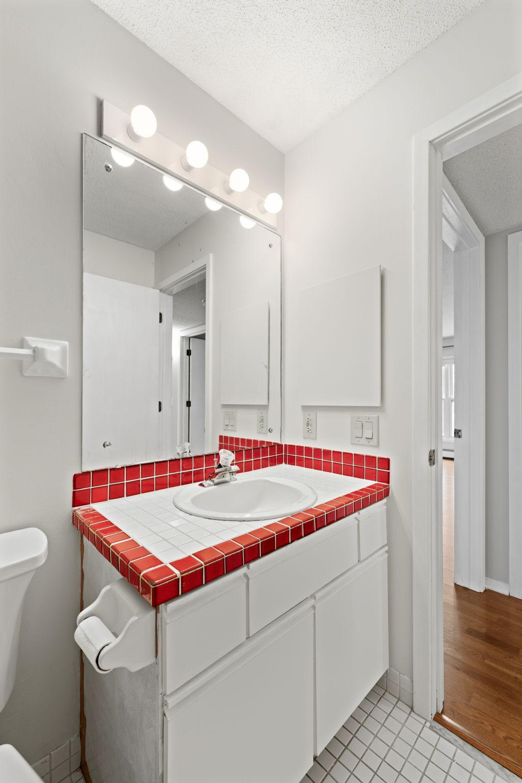 Guest bathroom showcasing vanity and oversized mirror. .