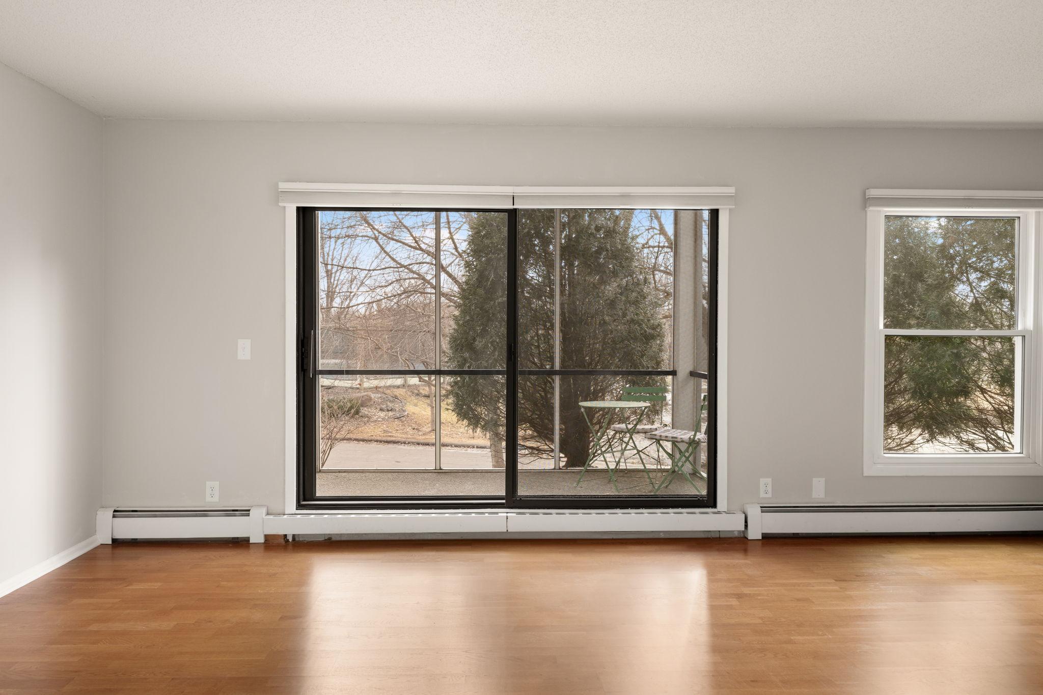 Large sliding glass door fills the living area with natural light and opens to the screened porch.