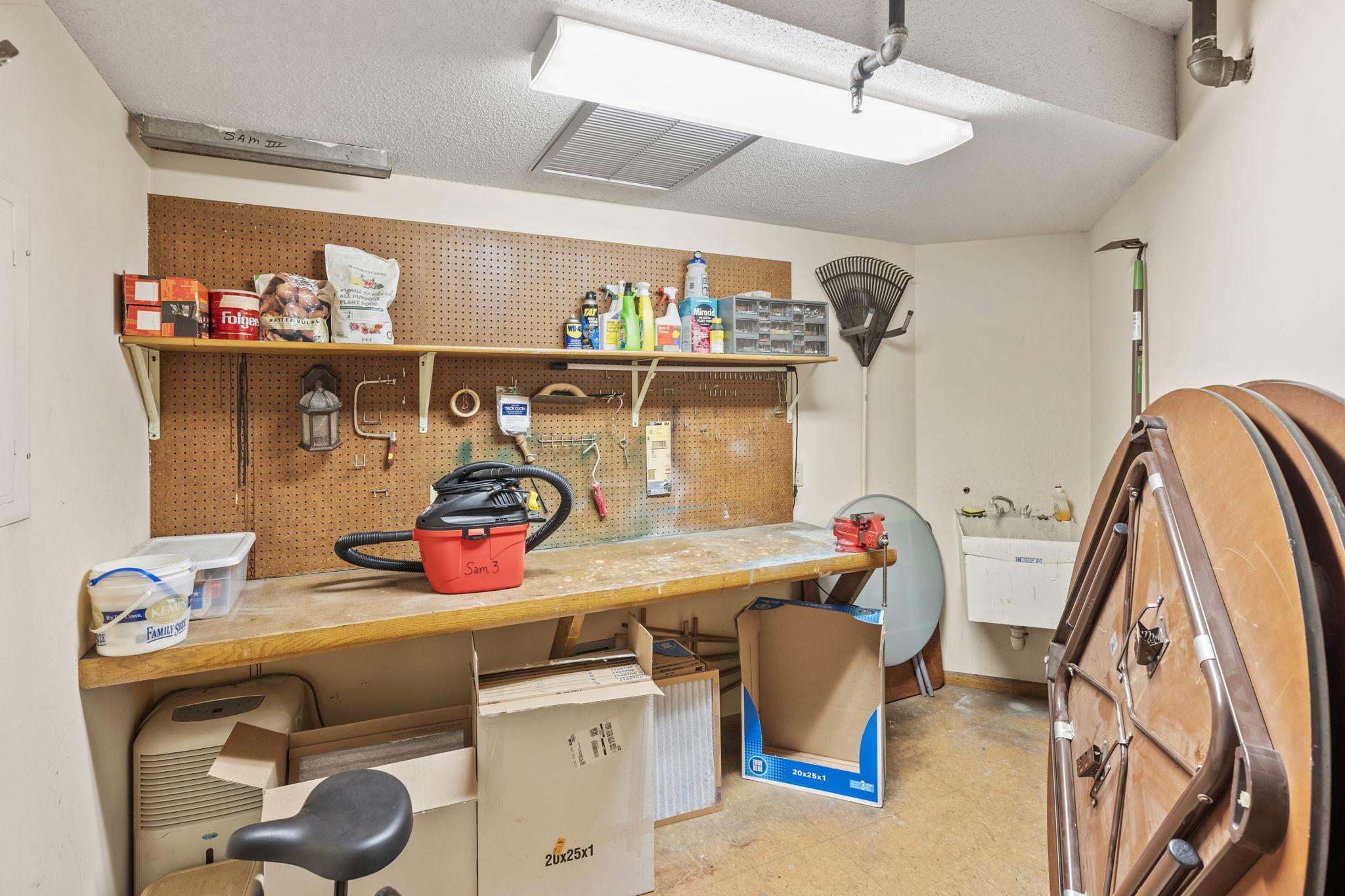 Workshop/hobby room with bench space and utility sink for projects and storage.