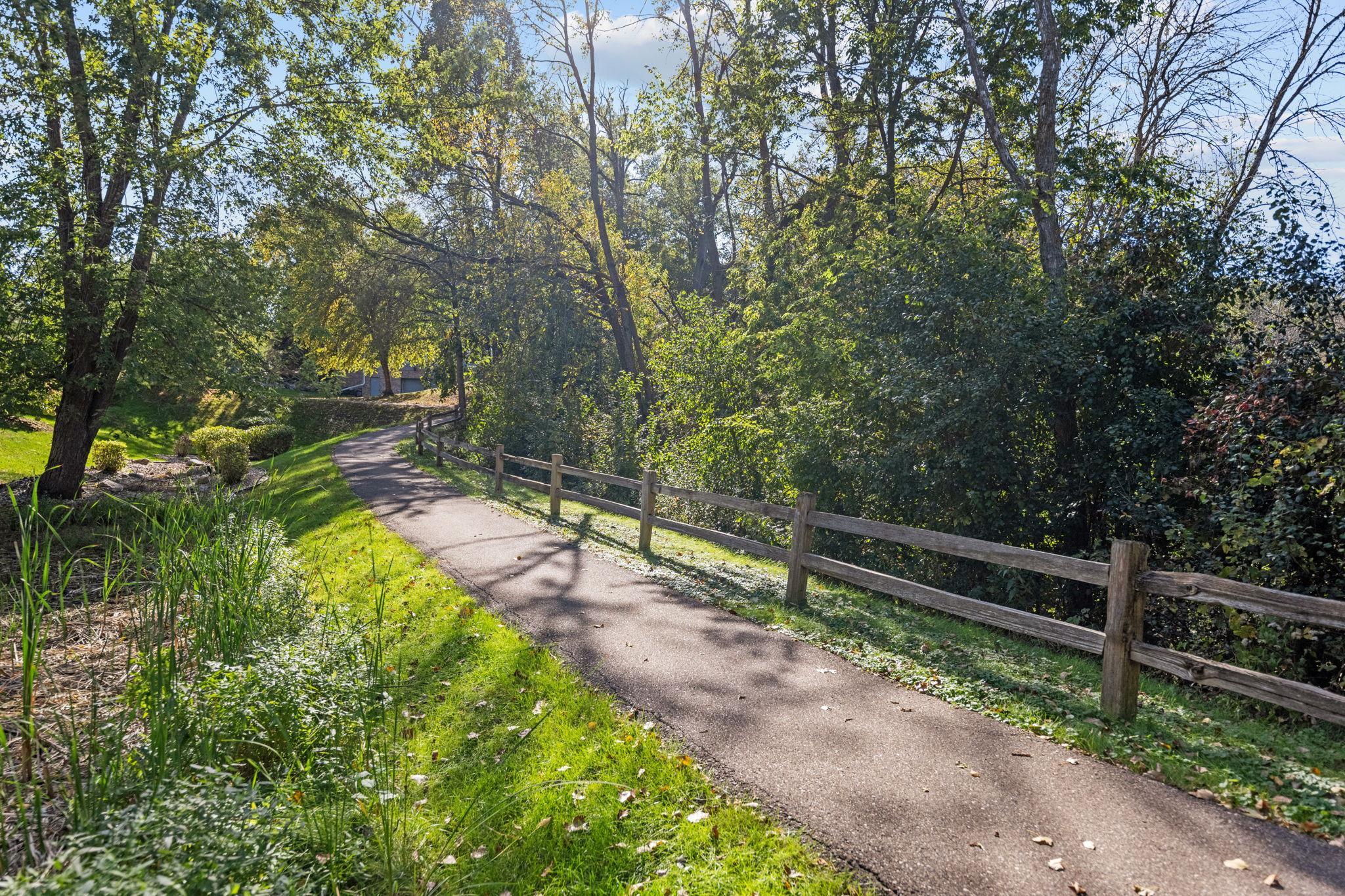 Scenic walking path winds through beautifully treed common grounds.